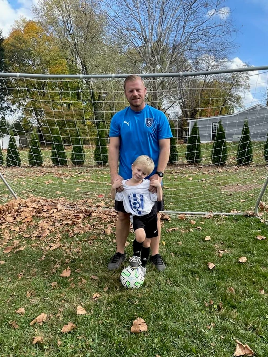 Young Lighthouse Soccer Club player in a new jersey with a soccer ball